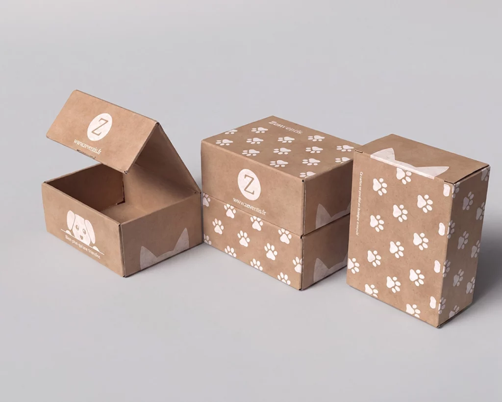 Gamme de packagings en carton kraft Zenventis pour chiens et chats, à motifs pattes et illustrations ludiques, dont une boîte ouverte dévoilant une illustration de chien